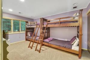 2 Etagenbetten in einem Zimmer mit lila Wänden in der Unterkunft Harbor Cove's Scenic Solitude in Harbor Springs