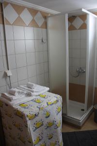 a bathroom with a shower with towels on a bed at Captain's Lodge in Ermoupoli