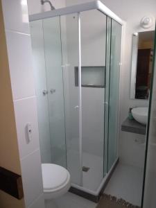 a bathroom with a toilet and a glass shower at Hospedagem Praia de Piratininga in Niterói