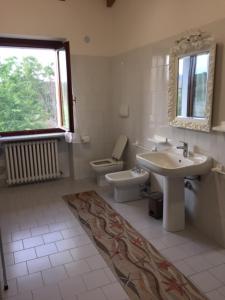 a bathroom with a sink and a toilet and a window at Foresto Case Vacanza in Volta Mantovana