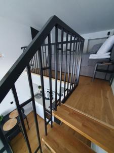 a staircase leading to a living room with a couch at Loft Style Studio Apartment- Free Parking- Free Gym- Keyless Access in Tartu +40 photos