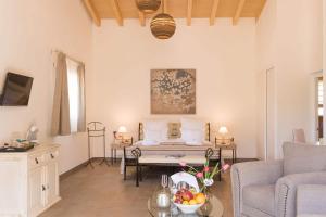 ein Wohnzimmer mit einem Bett und einem Tisch mit einer Obstschale in der Unterkunft Casa Font i Roig in Maria de la Salut