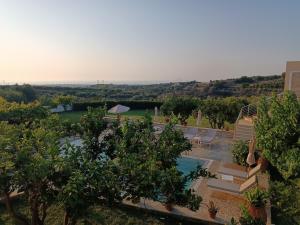 uma vista para uma piscina com cadeiras e árvores em Villa Stefania Dream em Érfoi