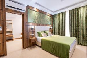 伊斯坦堡的住宿－Mardy Suit Hotel，一间卧室设有一张绿色的床和一个窗户。