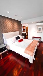 a bedroom with a large white bed with a red pillow at Loft de lujo ubicado en zona inmejorable Altamira in Caracas