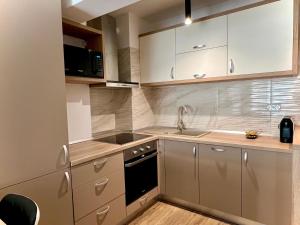 a kitchen with white cabinets and a sink at MM Residence in Cluj-Napoca