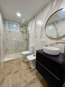 ein Badezimmer mit einem WC, einem Waschbecken und einem Spiegel in der Unterkunft HELICES CENTRO SAN JOSE CABO DE GATA in San José