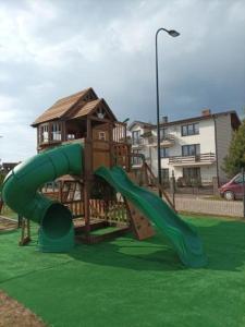 a playground with a slide in a park at Domki u strażaka in Jastarnia