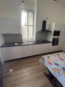 cocina con armarios blancos, fregadero y ventana en Apartment Mariuccia in Seborga, en Seborga