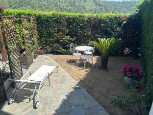 a patio with two tables and chairs and flowers at Apartment Mariuccia in Seborga in Seborga