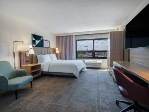 a hotel room with a bed and a large window at Staybridge Suites Chicago O'Hare - Rosemont by IHG in Rosemont