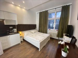 a bedroom with a white bed and a window at P&J Apartamenty Św. Krzyża in Krakow