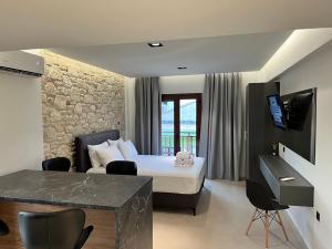 Habitación de hotel con cama y TV en InLofts, en Afitos