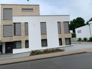 ein weißes Gebäude mit Fenstern auf der Straßenseite in der Unterkunft Mosaikhaus in Würselen