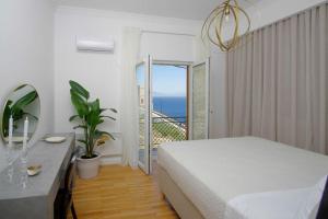 a bedroom with a bed and a view of the ocean at Lydia in Ermoupoli