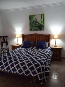 1 dormitorio con 1 cama azul y blanca y 2 lámparas en piso con desayuno incluido y vistas a la montaña., en Monistrol