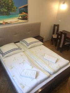 1 cama grande con 2 almohadas encima en P&J Apartamenty Św. Krzyża, en Cracovia