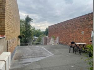 un patio con tavolo e sedie accanto a un muro di mattoni di Studio Flat without kitchen at Kentish Town a Londra