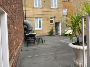 eine Terrasse mit Stühlen und einem Tisch neben einem Backsteingebäude in der Unterkunft Studio Flat without kitchen at Kentish Town in London