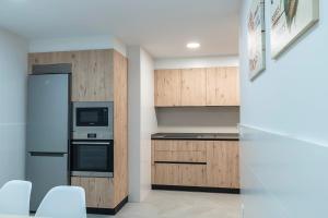 a kitchen with stainless steel appliances and wooden cabinets at Funcional y renovado apartamento en Iturrama in Pamplona