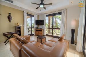 uma sala de estar com um sofá de couro e uma televisão de ecrã plano em Bahia Encantada beach front proyect, Jaco Paradise em Jacó