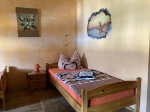 ein kleines Schlafzimmer mit einem Bett und einem Spiegel an der Wand in der Unterkunft Doppelzimmer vom Friesenhof Wieratal 