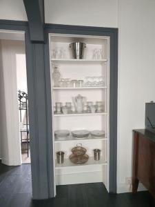 a white shelf with dishes on it in a room at Les falaises d Etretat Etretat hypercentre duplex 50m de la mer & parking in Étretat