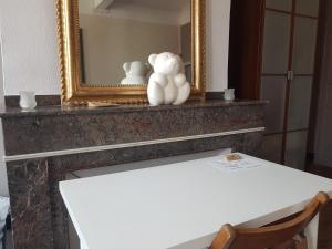 a table with a mirror and two white sculptures on it at Artbnb in Lézat-sur-Lèze