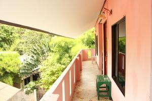 a balcony of a house with a green chair at Miss Tim House in Ko Samed