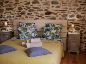 una camera da letto con un letto grande con cuscini sopra di Les Jardins de Lumière a Brusque
