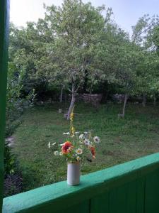 um vaso de flores sentado numa cerca em Guest House Guliada em Gordi
