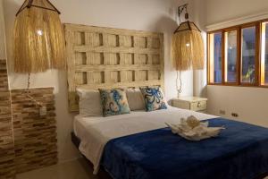 1 dormitorio con 1 cama grande y cabecero de madera en Galapagos Planet Hotel en Puerto Baquerizo Moreno