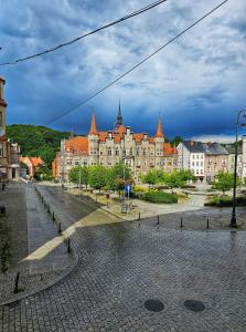 a large building with orange roofs on a city street at Noclegi Wałbrzych Centrum in Wałbrzych