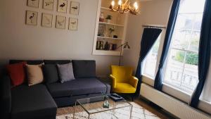 a living room with a blue couch and a yellow chair at Willoughby Apartment in Bath
