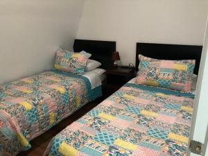 two beds sitting next to each other in a room at Departamentos comodos y hermosos full equipados con baño y cocina privados in Santiago