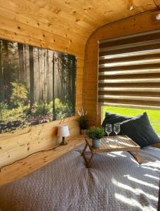 uma cabina de madeira com uma mesa e uma grande janela em Doles skati em Salaspils