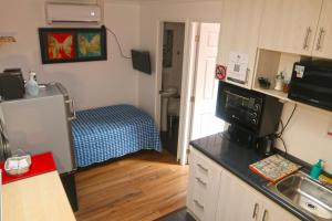 a kitchen with a refrigerator and a bed in a room at Comfortable and beautiful apartments fully equipped with private bathroom and kitchen in Santiago