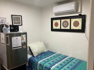 a small room with a bed and a refrigerator at Departamentos comodos y hermosos full equipados con baño y cocina privados in Santiago +44 photos