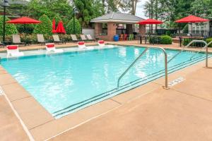 a swimming pool at a hotel with chairs and umbrellas at East Atlanta Retreat Haven of Fun and Comfort! in Atlanta