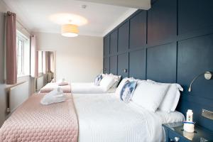 Duas camas num quarto com paredes azuis em Adare Guesthouse em Galway