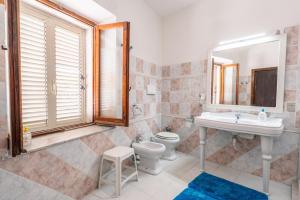 a bathroom with a sink toilet and a mirror at Casa Vacanze Relaxia in Posada