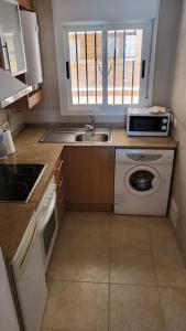 a small kitchen with a sink and a microwave at Apartamento Torremar M in El Borseral