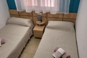 two beds in a small room with a window at Apartamento Torremar M in El Borseral