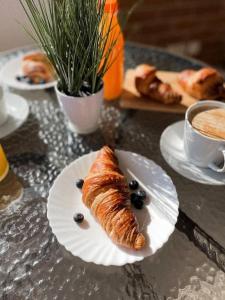 een tafel met een bord met een croissant en een kopje koffie bij Apartamento Torremar M in El Borseral