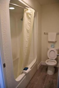 uma casa de banho com um chuveiro e um WC. em Rodeway Inn Kissimmee Maingate West em Orlando