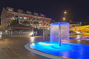 a water fountain in a courtyard at night at Apartamentos Esperanza del Mar in Portonovo