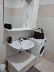 a bathroom with a sink and a washing machine at L&G APARTAMENT in Nago-Torbole