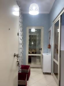 a bathroom with blue walls and a room with a mirror at Mirela’s Apartment City Center in Tirana