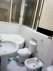 a white bathroom with a toilet and a sink at Mirela’s Apartment City Center in Tirana