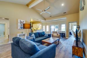 a living room with blue couches and a table at Spacious Lubbock Home with Private Pool and Yard! in Lubbock